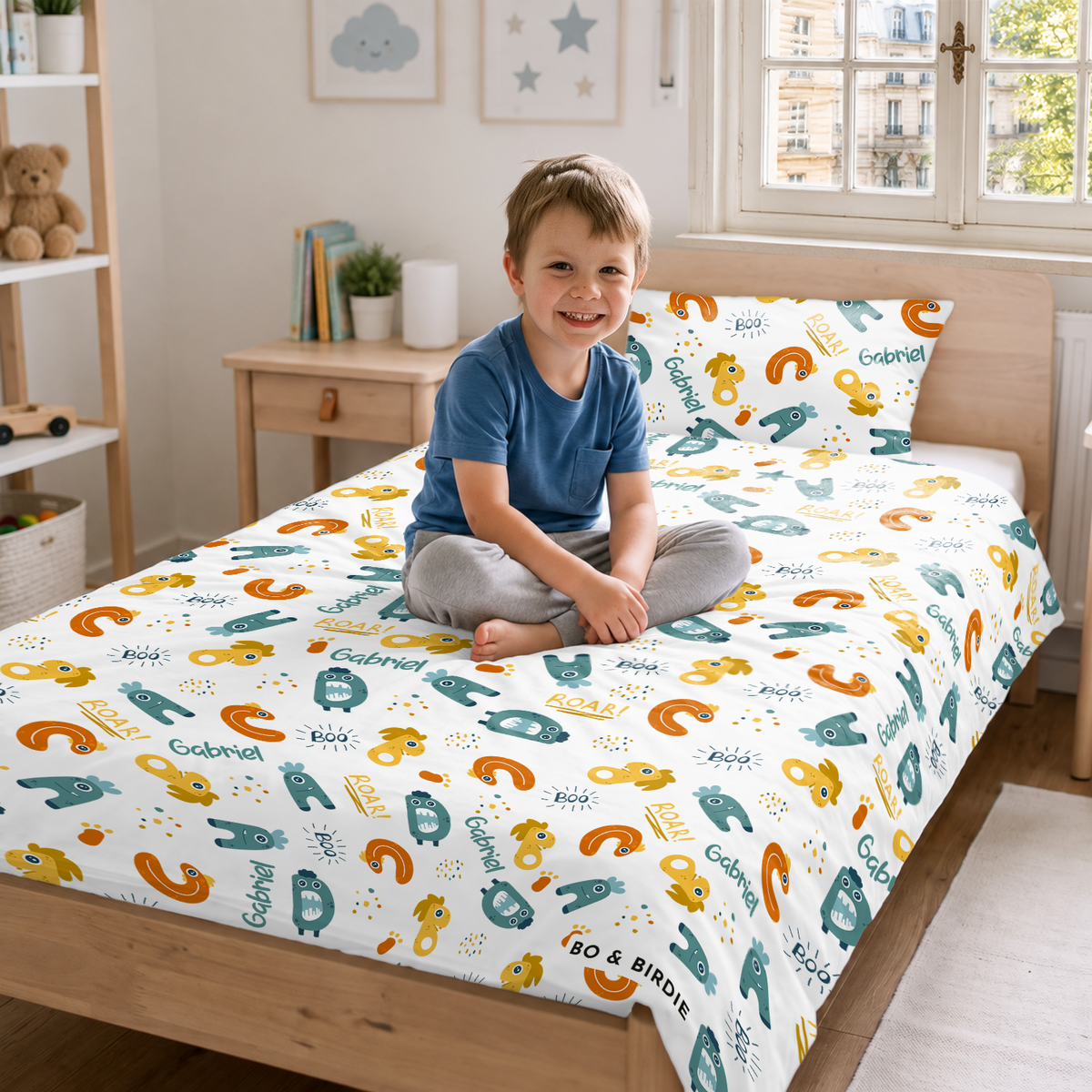 Garçon souriant assis sur le lit avec la parure Monstres et le prénom market_france